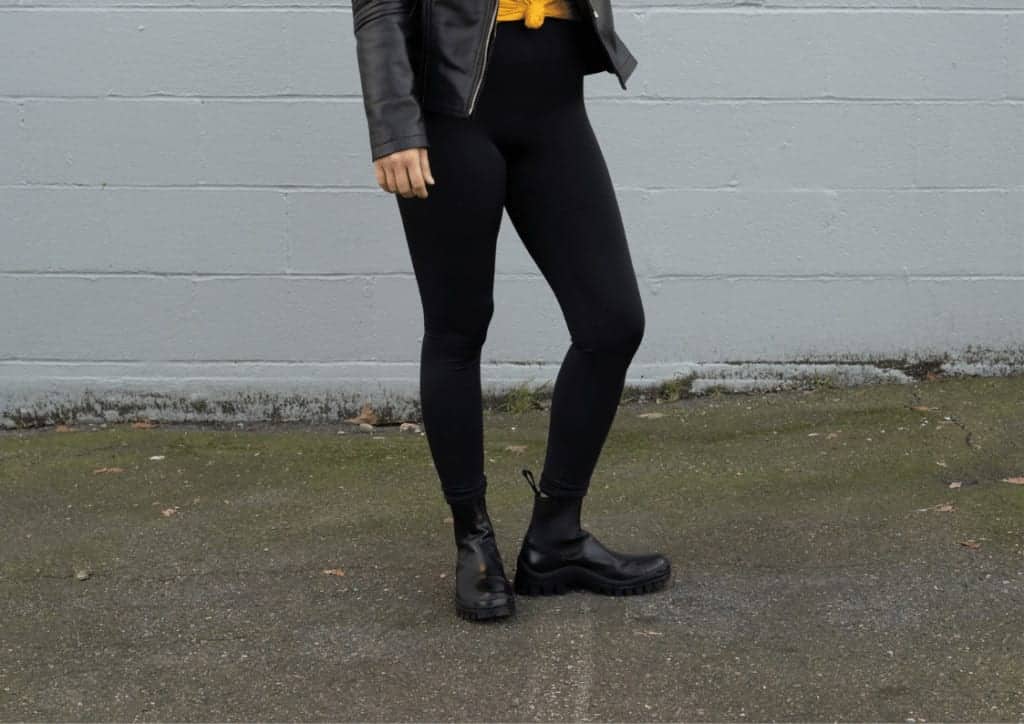 Black leggings being worn with ankle high black boots and a leather jacket