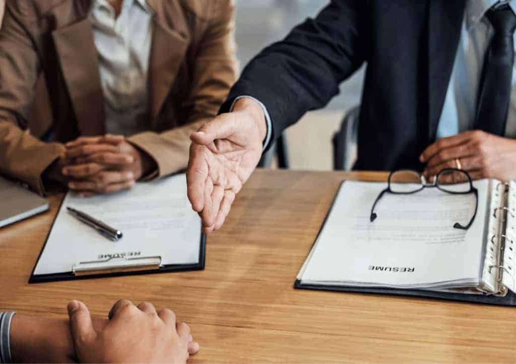 A handshake being offered to signify being awarded a new job